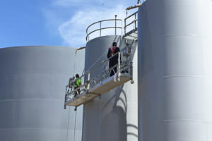 Guelph industrial painters spray painting large steel tanks