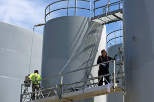 workers spray painting steel storage tanks in Oakville, Ontario