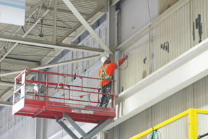 Whitby industrial painter spray painting a large wall