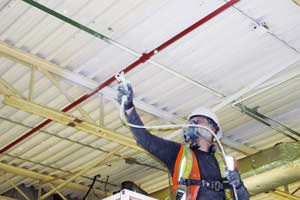 spray painting underway of dirty steel ceiling by a painter