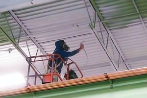 painting of a metal deck ceiling by an industrial spray painter